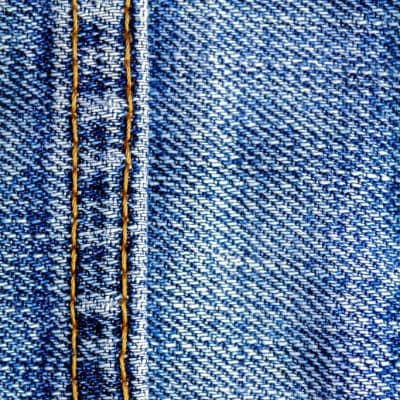 Costura original de un jean recuperado, con el hilo naranja a la vista