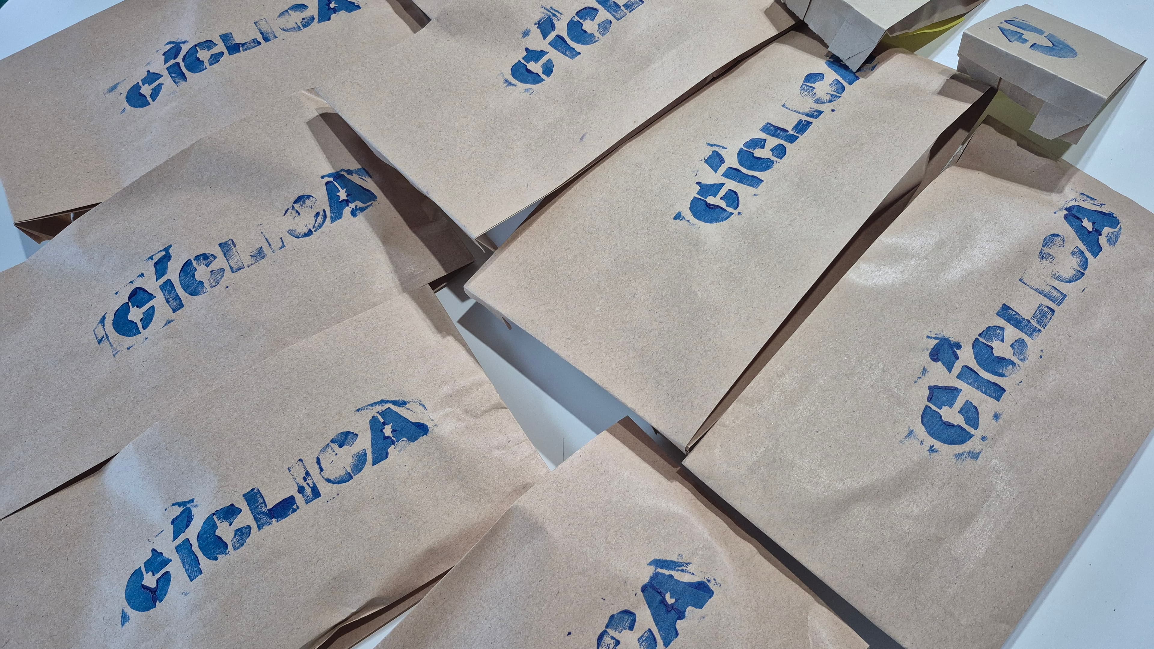 Bolsas de papel madera con el logotipo de CÍCLICA estampado en azul con esténcil