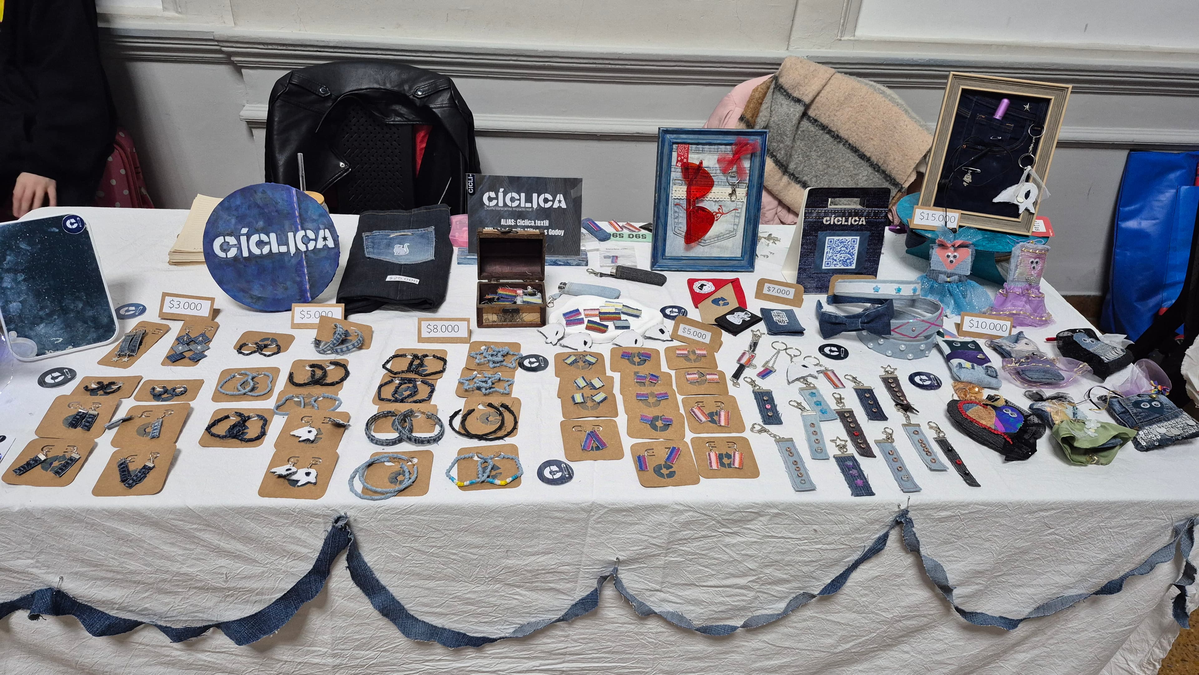 La mesa de CÍCLICA en una feria: aros, llaveros, pins y vinchas hechos con denim recuperado